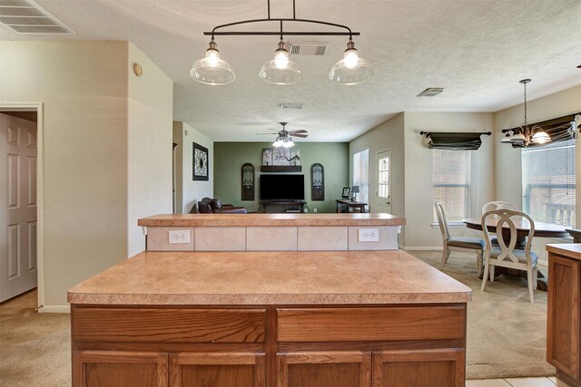 kitchen with a healthy amount of sunlight, visible vents, and light carpet