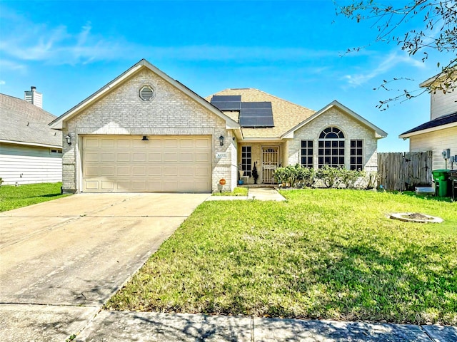 ranch-style house featuring solar panels, a front lawn, fence, a garage, and driveway