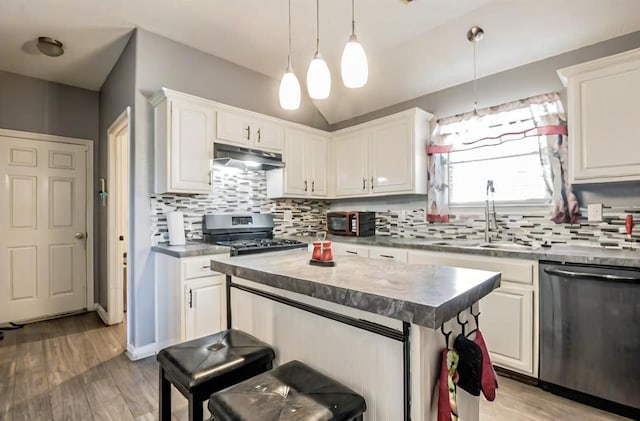 kitchen featuring under cabinet range hood, tasteful backsplash, appliances with stainless steel finishes, and a sink