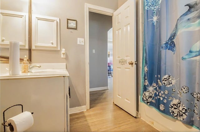 full bathroom featuring vanity, shower / bath combo, wood finished floors, and baseboards