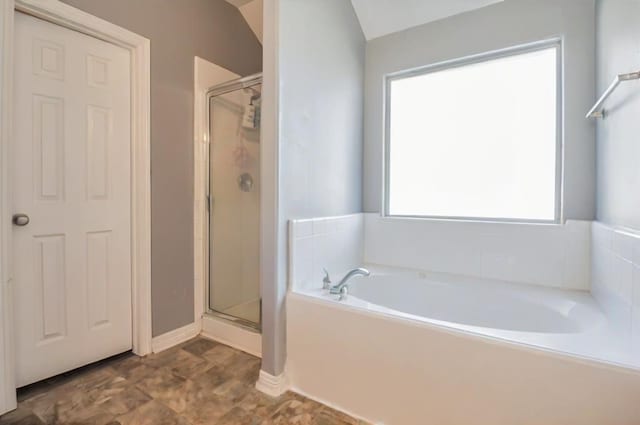 bathroom with a stall shower and a garden tub