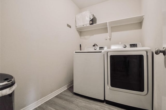 laundry area featuring laundry area, light wood-style flooring, baseboards, and washer and clothes dryer