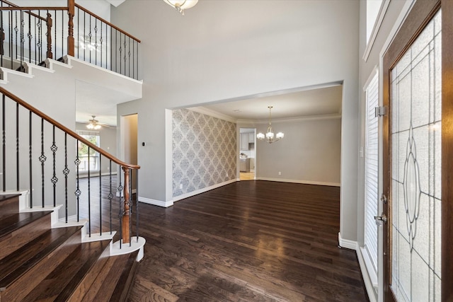 foyer entrance featuring stairs, a high ceiling, baseboards, and wood finished floors