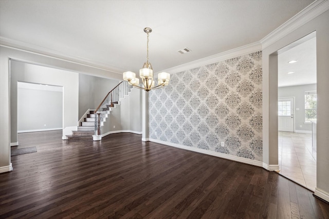 spare room featuring visible vents, wallpapered walls, baseboards, stairway, and wood finished floors