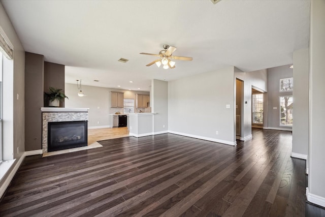 unfurnished living room with visible vents, baseboards, and wood finished floors