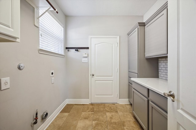 laundry area featuring cabinet space, baseboards, gas dryer hookup, and electric dryer hookup