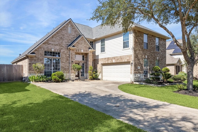 traditional-style home with fence, an attached garage, a front lawn, concrete driveway, and brick siding