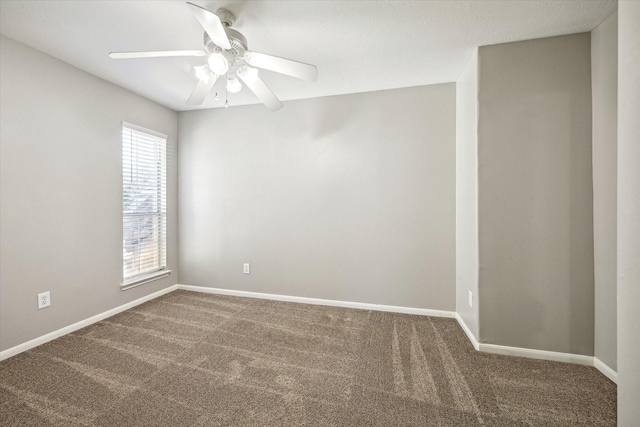 carpeted spare room featuring baseboards and ceiling fan