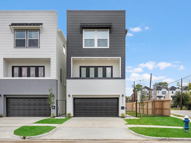 view of front facade featuring an attached garage, concrete driveway, and fence