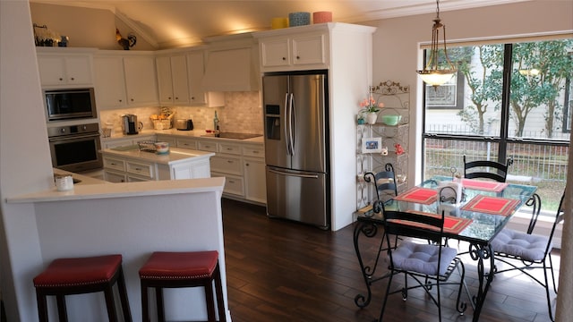 kitchen featuring backsplash, appliances with stainless steel finishes, white cabinets, crown molding, and wall chimney range hood