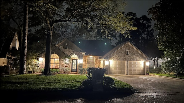 view of front of property featuring a garage, stone siding, a lawn, and concrete driveway