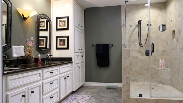 bathroom with tile patterned floors, a shower stall, vanity, and baseboards