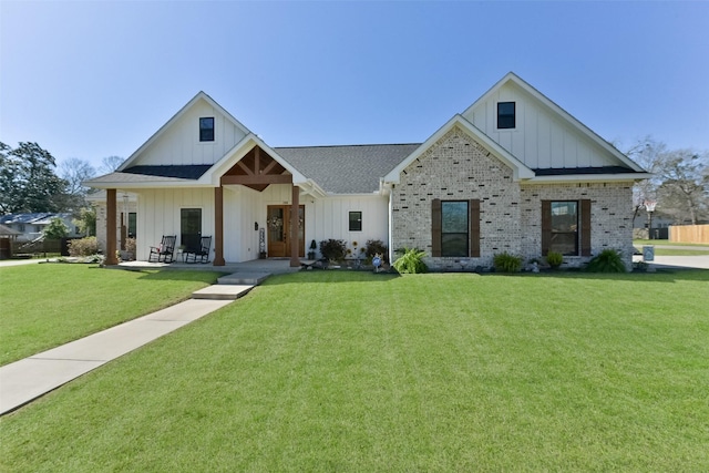 modern farmhouse style home with a front yard, brick siding, and board and batten siding