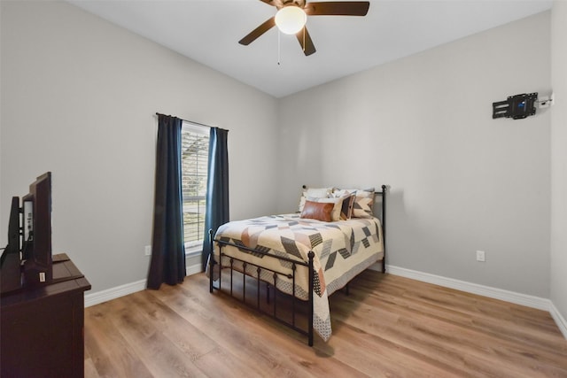 bedroom with baseboards, light wood-style flooring, and a ceiling fan