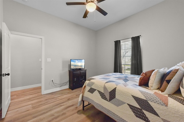 bedroom with baseboards, light wood-style floors, and a ceiling fan