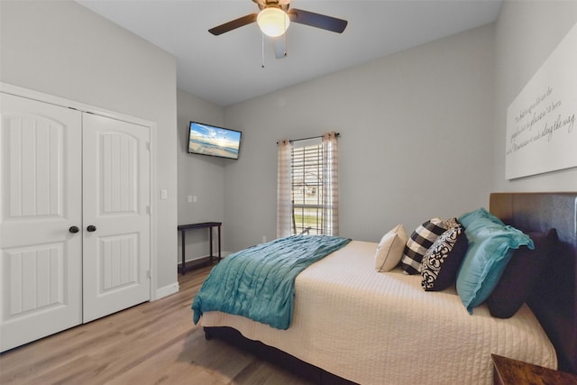 bedroom featuring ceiling fan, a closet, baseboards, and wood finished floors