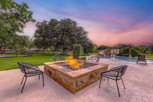 view of patio featuring an outdoor pool, an outdoor fire pit, and fence