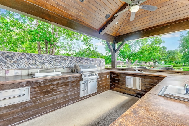 view of patio featuring grilling area, area for grilling, a ceiling fan, and fence