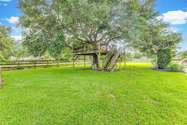 view of yard featuring stairway, a deck, and fence