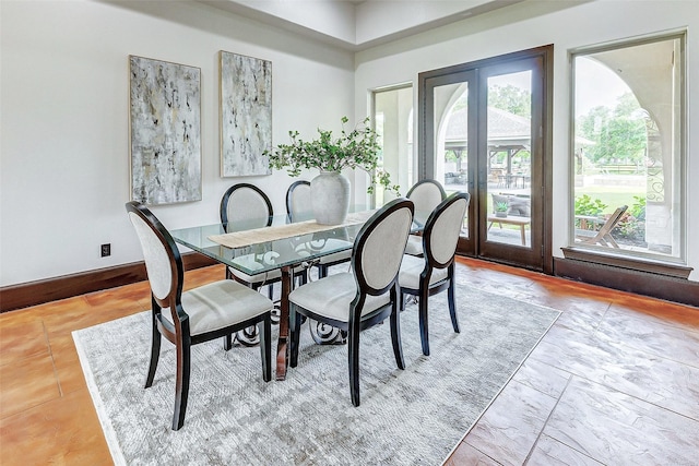 dining space featuring french doors and baseboards