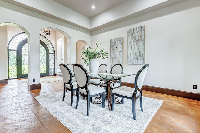 dining room with recessed lighting, baseboards, and arched walkways