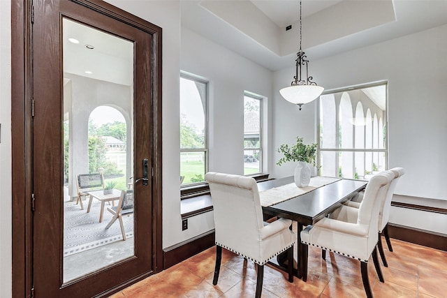 dining space featuring light tile patterned floors, a raised ceiling, and recessed lighting