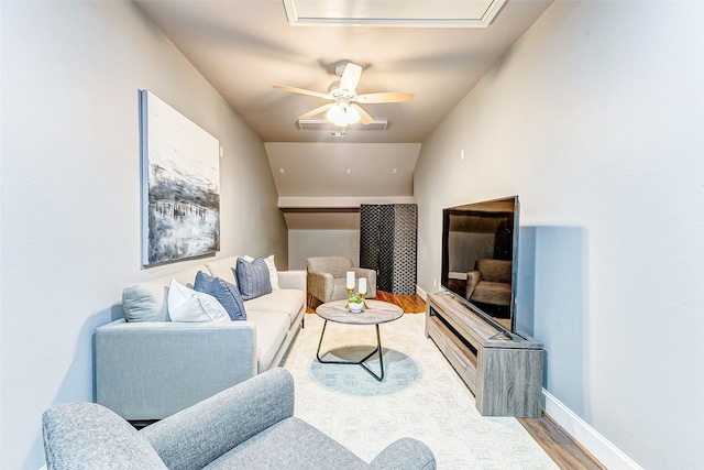 living area with baseboards, wood finished floors, and a ceiling fan