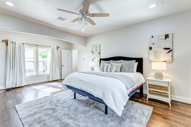 bedroom featuring a ceiling fan, wood finished floors, visible vents, baseboards, and recessed lighting