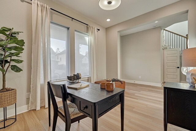 office featuring a wealth of natural light, light wood-type flooring, and baseboards