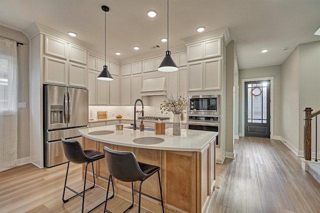 kitchen featuring visible vents, backsplash, premium range hood, light countertops, and stainless steel appliances