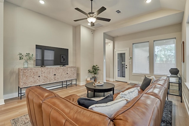 living area with visible vents, baseboards, and wood finished floors