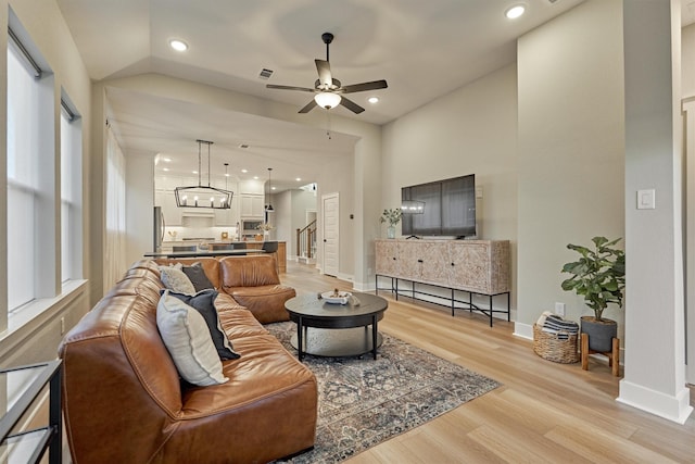 living area featuring recessed lighting, light wood-style floors, and stairs