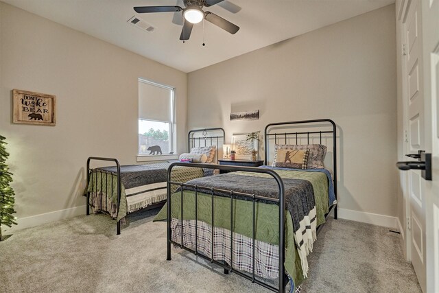 carpeted bedroom with visible vents, baseboards, and a ceiling fan