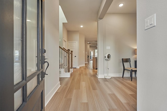 entryway with stairway, recessed lighting, baseboards, and light wood finished floors