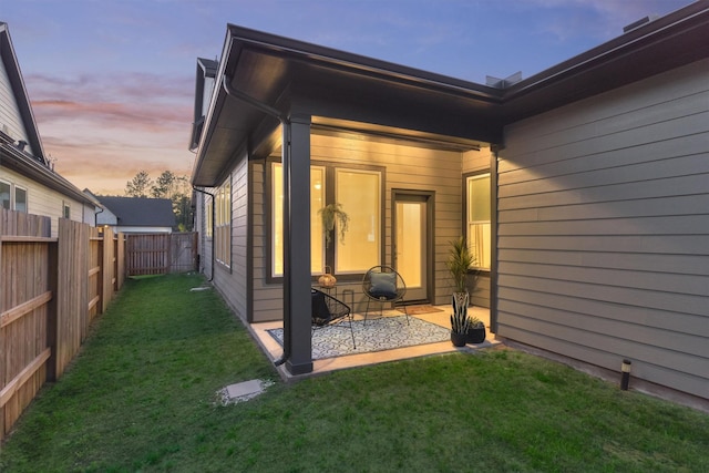 back of property featuring a yard, a patio, and a fenced backyard