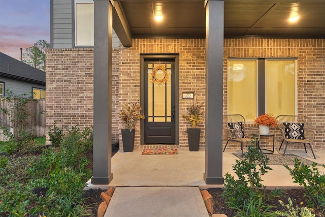 property entrance featuring brick siding and covered porch