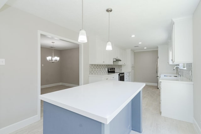 kitchen with tasteful backsplash, stainless steel appliances, under cabinet range hood, and a sink