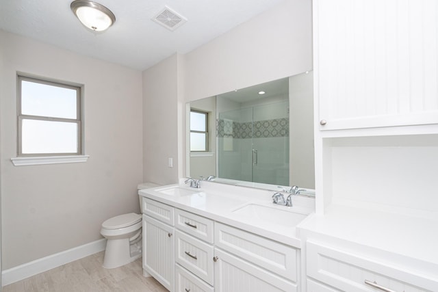 bathroom featuring visible vents, a shower stall, toilet, and a sink