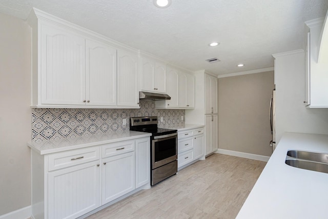 kitchen featuring visible vents, under cabinet range hood, tasteful backsplash, stainless steel range with electric cooktop, and white cabinets