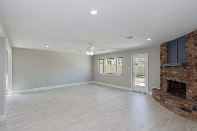 unfurnished living room featuring visible vents, ceiling fan, baseboards, a fireplace, and light wood-style floors