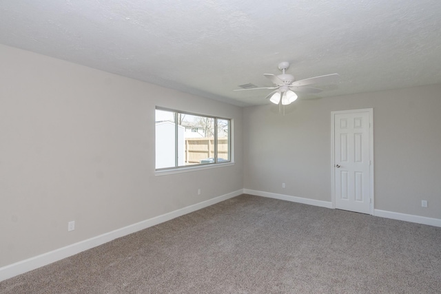 empty room with a ceiling fan, baseboards, carpet floors, and a textured ceiling