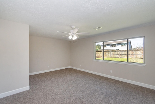 carpeted spare room featuring visible vents, ceiling fan, a textured ceiling, and baseboards