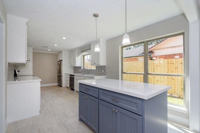 kitchen with tasteful backsplash, dishwasher, light countertops, freestanding refrigerator, and white cabinetry