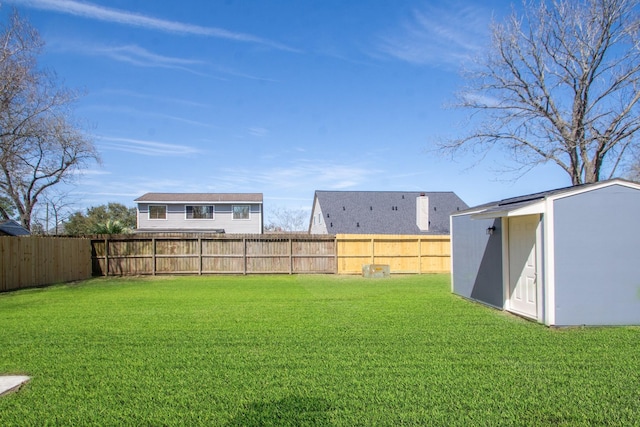 view of yard featuring an outbuilding, a fenced backyard, and a shed