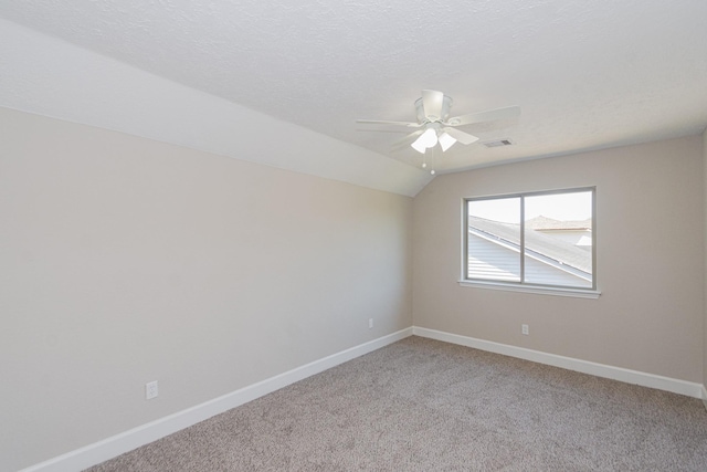 unfurnished room with baseboards, visible vents, lofted ceiling, ceiling fan, and light carpet