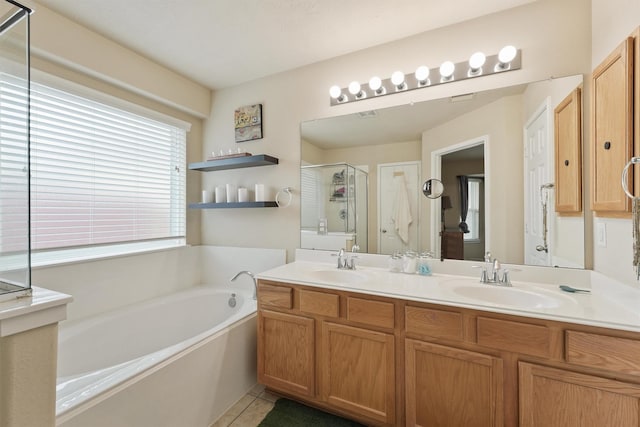 bathroom featuring double vanity, a stall shower, a sink, tile patterned flooring, and a garden tub