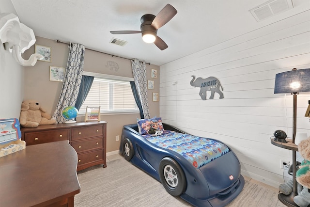 bedroom with visible vents, baseboards, light colored carpet, and ceiling fan