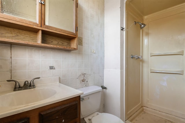 full bathroom featuring toilet, vanity, decorative backsplash, a stall shower, and tile walls