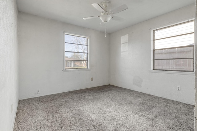 spare room featuring carpet flooring and a ceiling fan