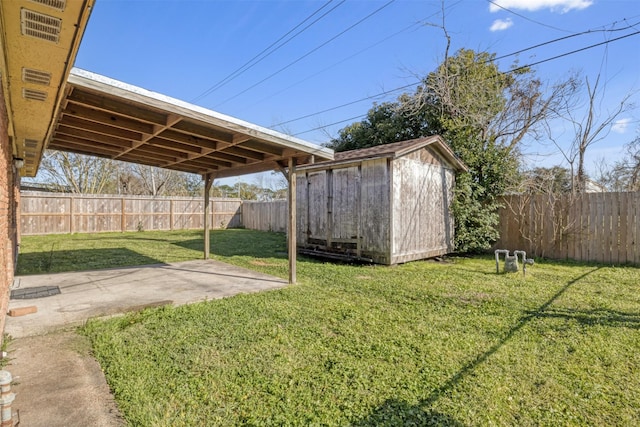 view of yard with a storage shed, an outbuilding, a fenced backyard, and a patio